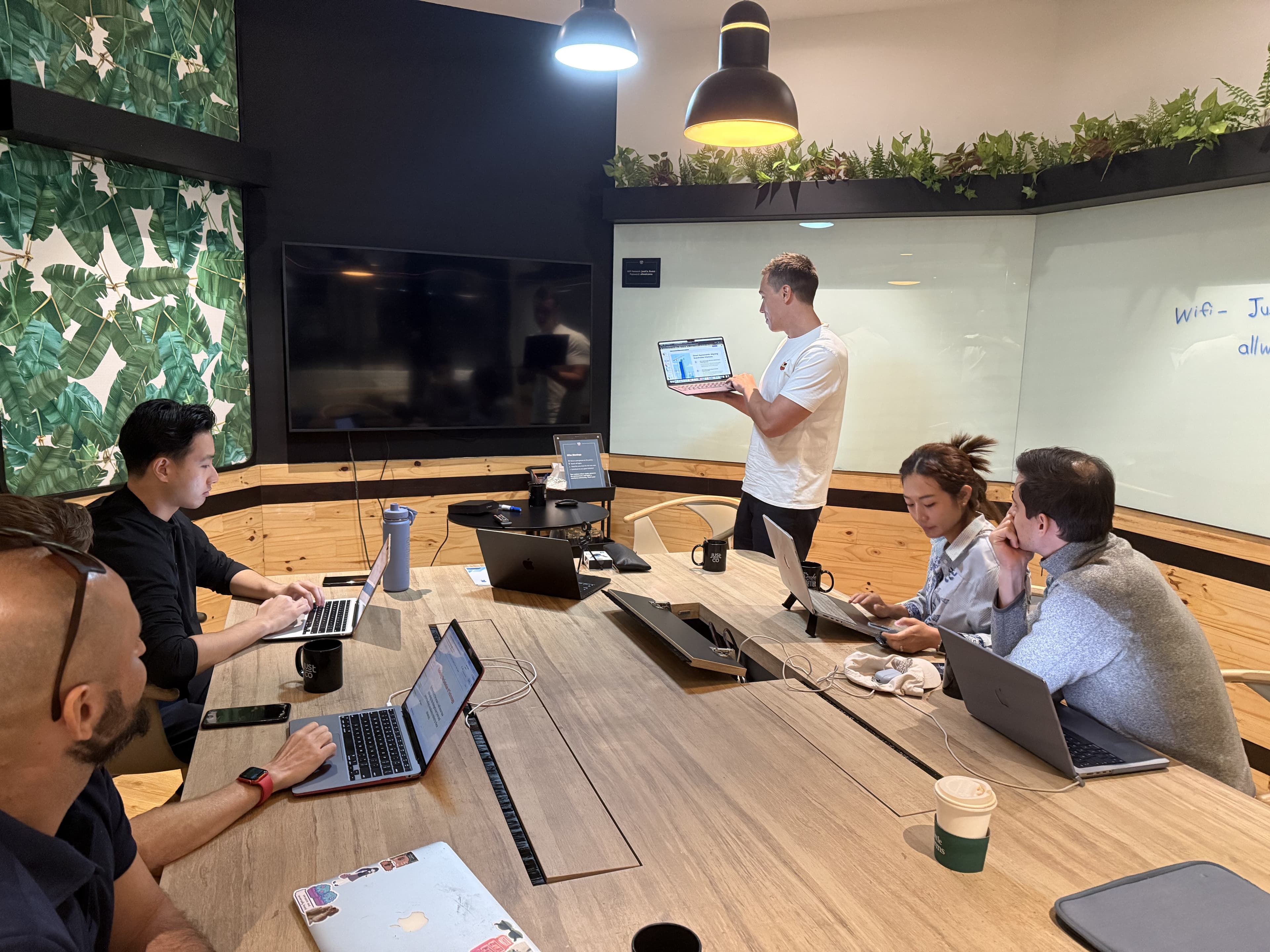 Alan Brown teaching adults around a long table during a Marketing with AI workshop in Singapore